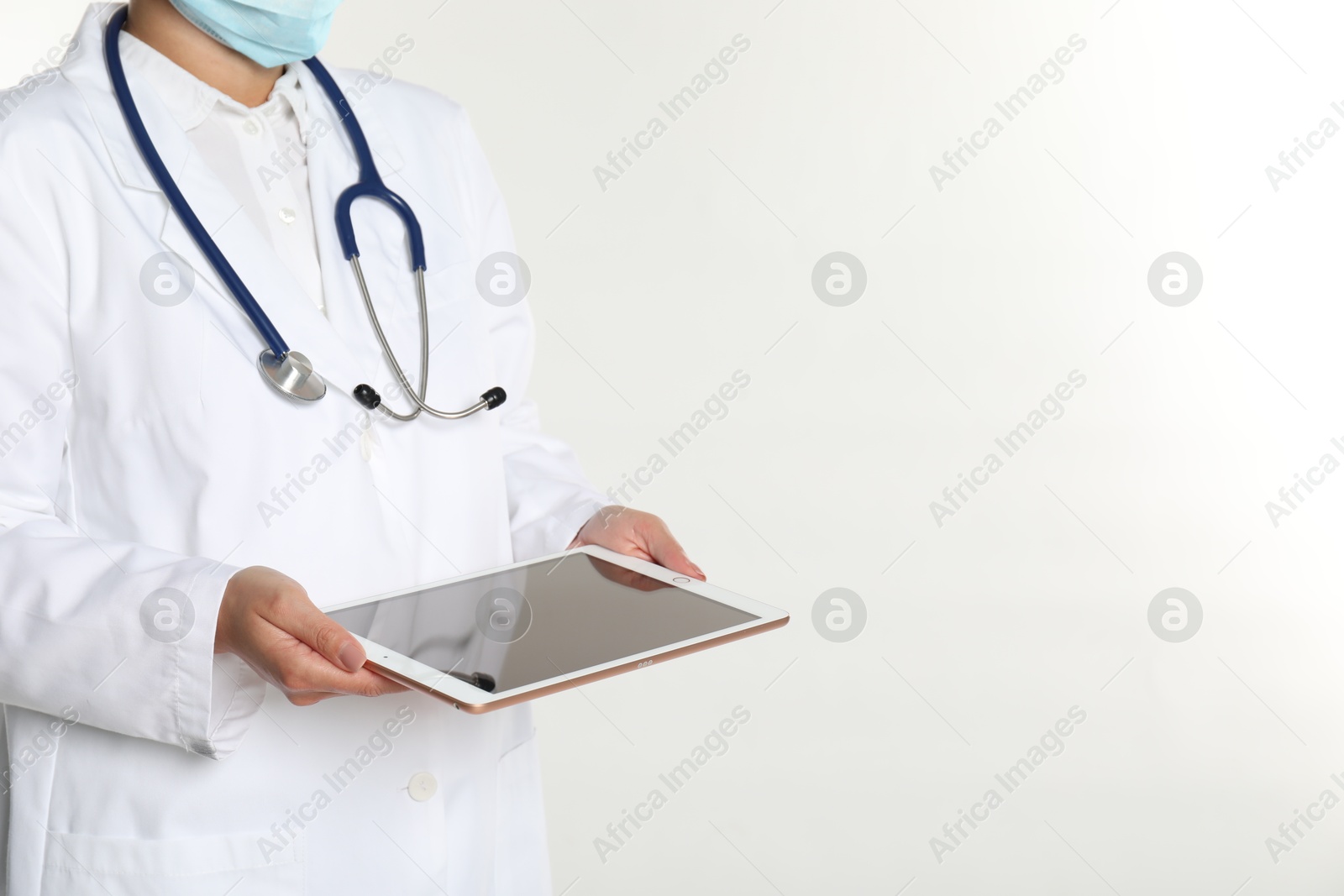 Photo of Doctor with tablet on white background, closeup view. Space for text