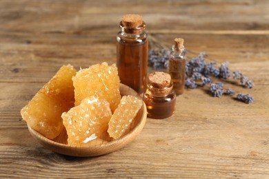 Photo of Natural honey tincture, lavender and sweet honeycombs on wooden table