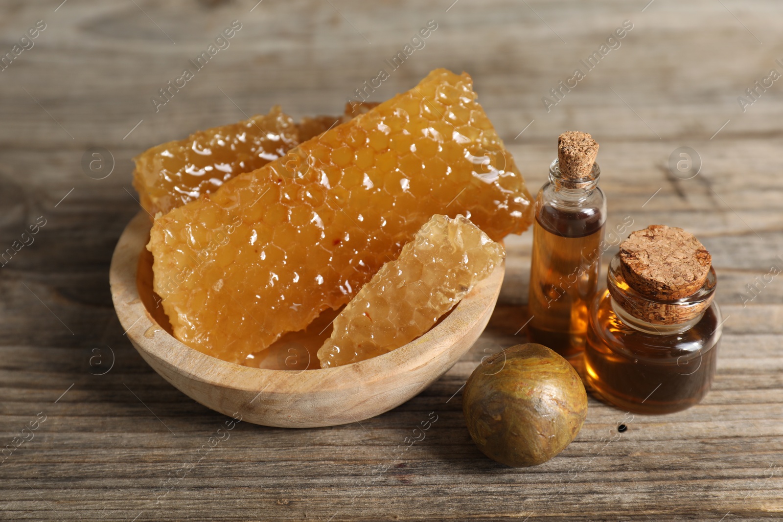 Photo of Natural honey tincture and sweet honeycombs on wooden table