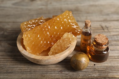 Photo of Natural honey tincture and sweet honeycombs on wooden table