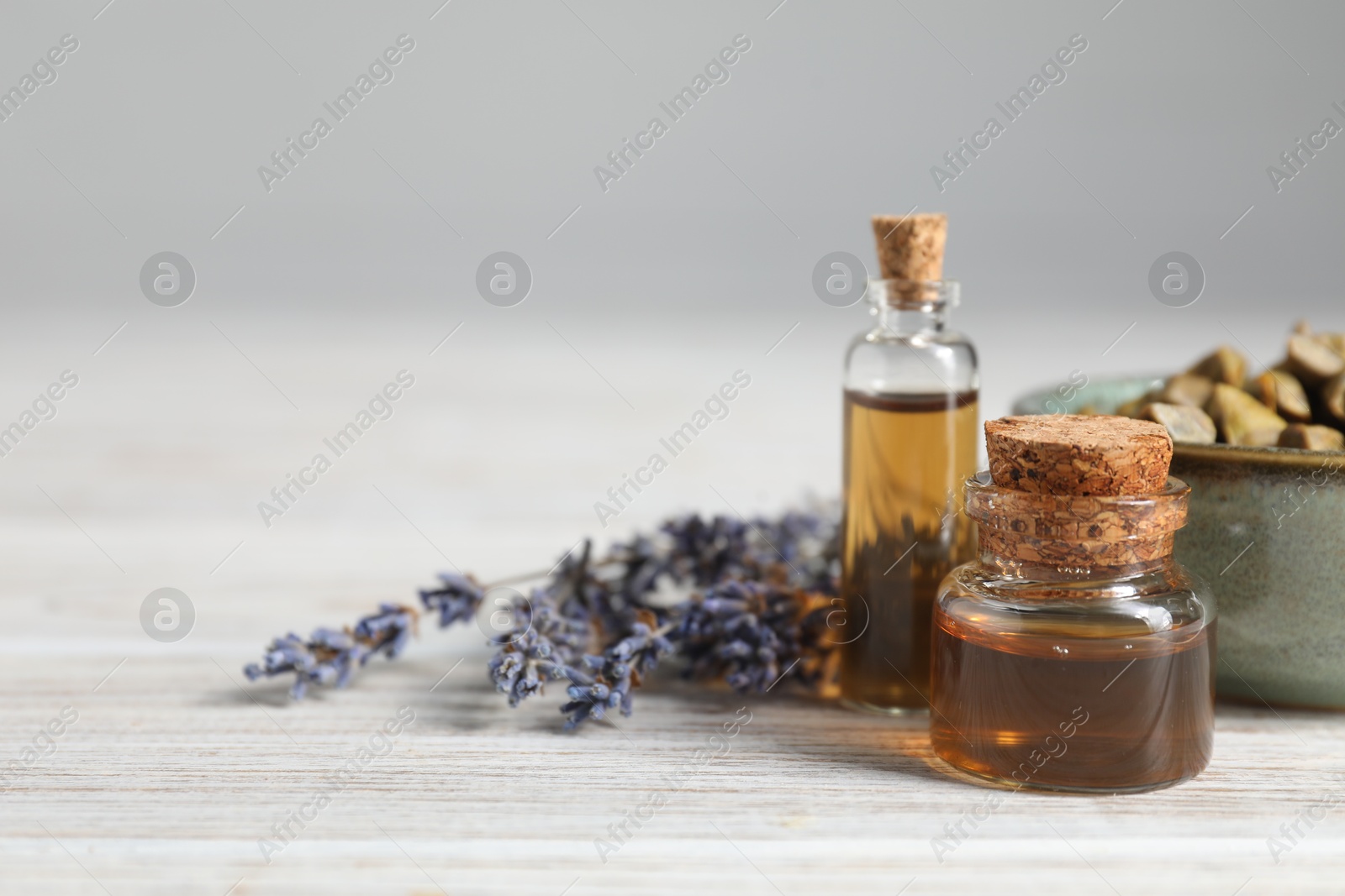 Photo of Natural honey tincture, lavender and propolis granules on white wooden table, closeup. Space for text