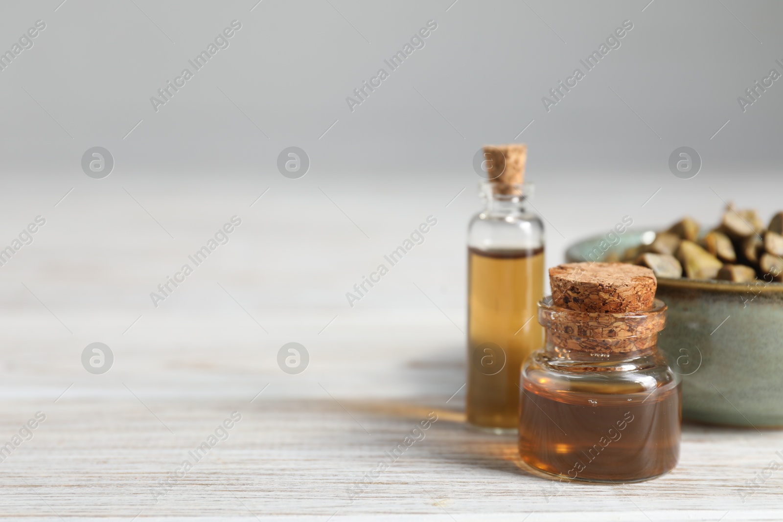 Photo of Natural honey tincture and propolis granules on white wooden table, closeup. Space for text