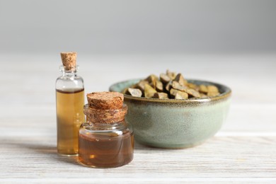 Photo of Natural honey tincture and propolis granules on white wooden table