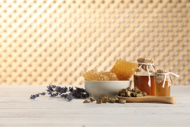 Photo of Natural honey tincture, lavender, propolis granules and sweet honeycombs on white wooden table, space for text