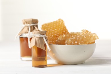 Photo of Natural honey tincture and sweet honeycombs on white wooden table