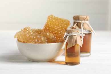 Photo of Natural honey tincture and sweet honeycombs on white wooden table