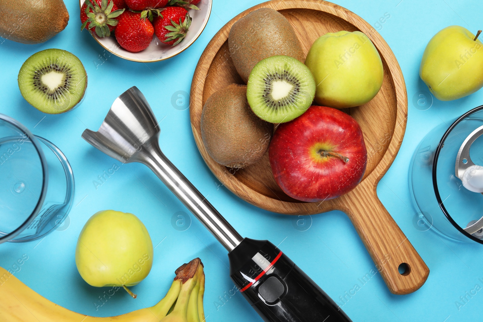 Photo of Hand blender kit and fresh fruits on light blue background, flat lay