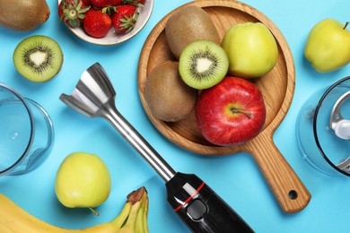 Hand blender kit and fresh fruits on light blue background, flat lay