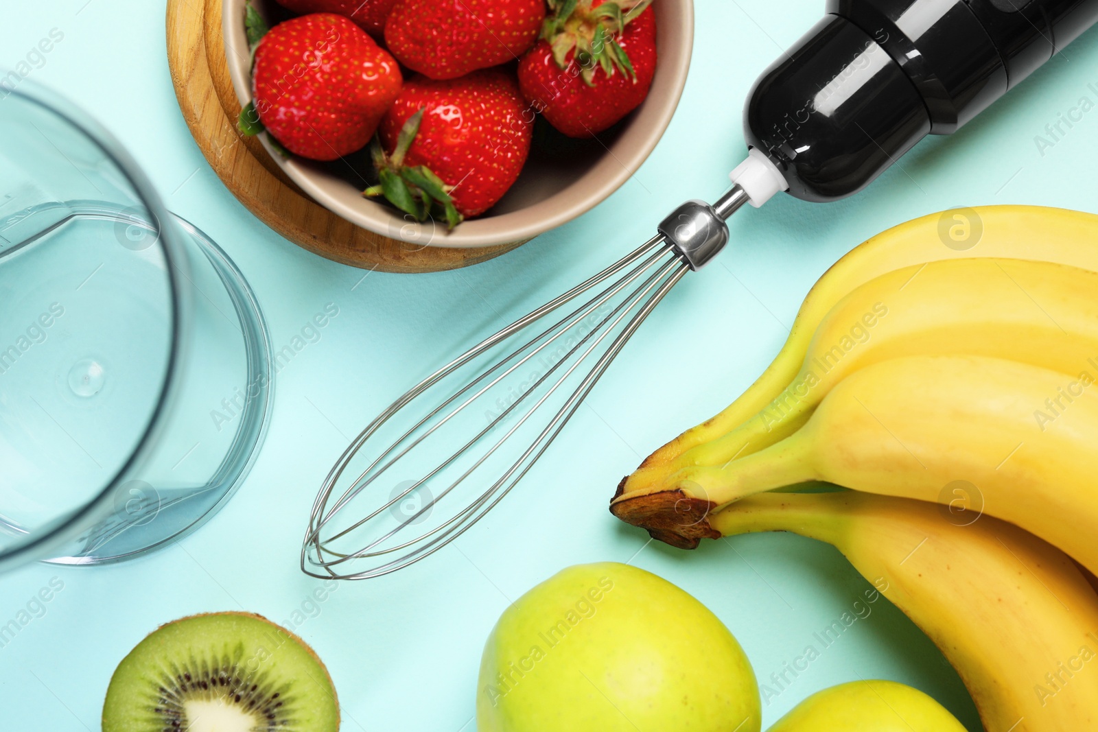 Photo of Hand blender kit and fresh fruits on light blue background, flat lay