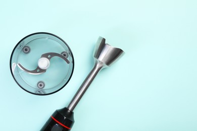 Photo of Hand blender kit. Blending shaft, bowl and blade on light blue background, top view. Space for text