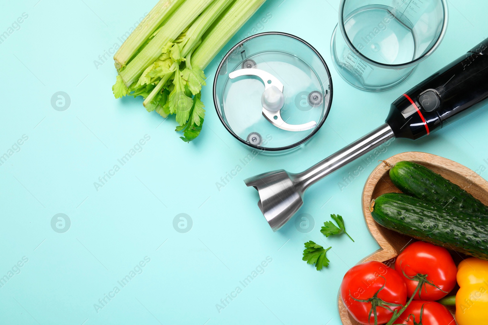 Photo of Hand blender kit and fresh products on light blue background, flat lay. Space for text