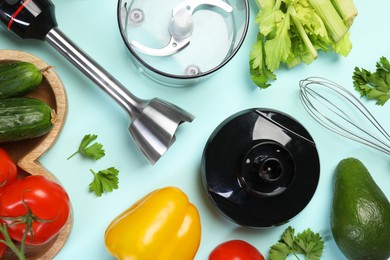 Hand blender kit and fresh products on light blue background, flat lay