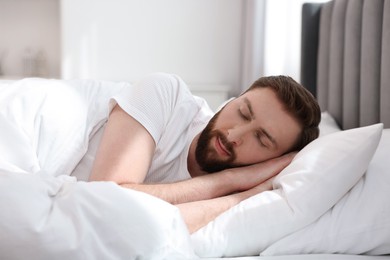 Photo of Handsome young man sleeping in bed at morning