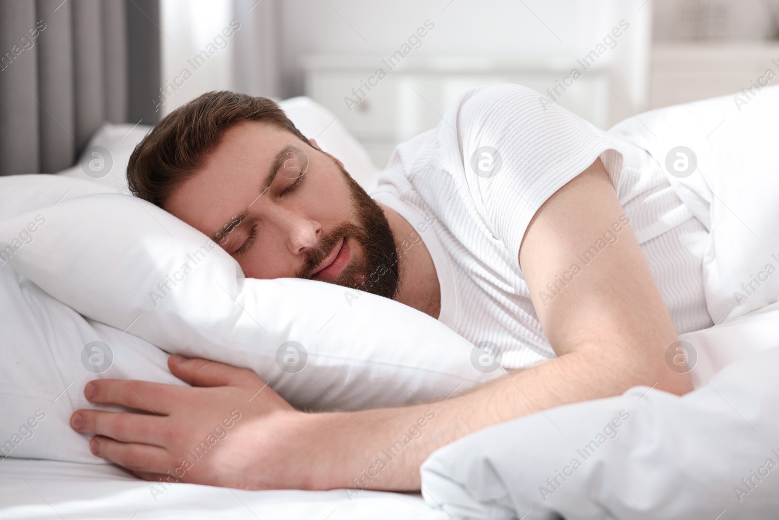 Photo of Handsome young man sleeping in bed at morning