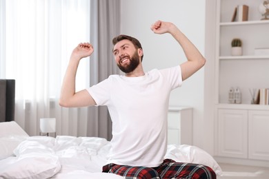 Photo of Young man stretching on bed at morning