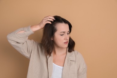 Photo of Woman with hair loss problem on beige background