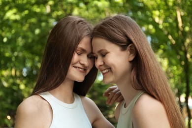 Photo of Portrait of two beautiful twin sisters in park, closeup