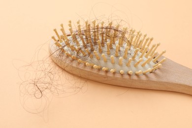 Photo of One brush with lost hair on beige background, closeup. Alopecia problem