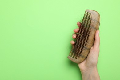 Photo of Woman with comb and lost hair on light green background, top view. Space for text