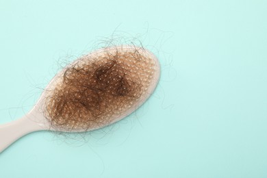 One brush with lost hair on light blue background, top view. Space for text