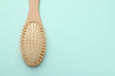 One brush with lost hair on light blue background, top view. Space for text