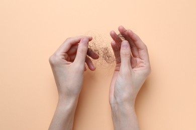 Woman with lost hair on beige background, top view. Alopecia problem