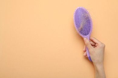 Woman with brush and lost hair on coral background, top view. Space for text