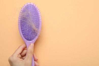 Photo of Woman with brush and lost hair on coral background, top view. Space for text