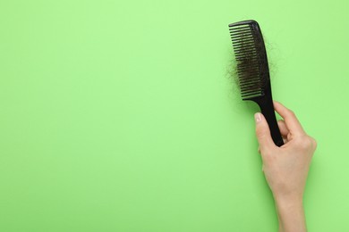 Photo of Woman with comb and lost hair on light green background, top view. Space for text