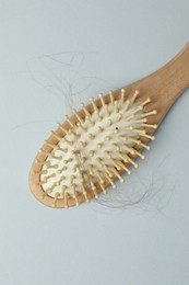 Photo of One brush with lost hair on grey background, top view. Alopecia problem