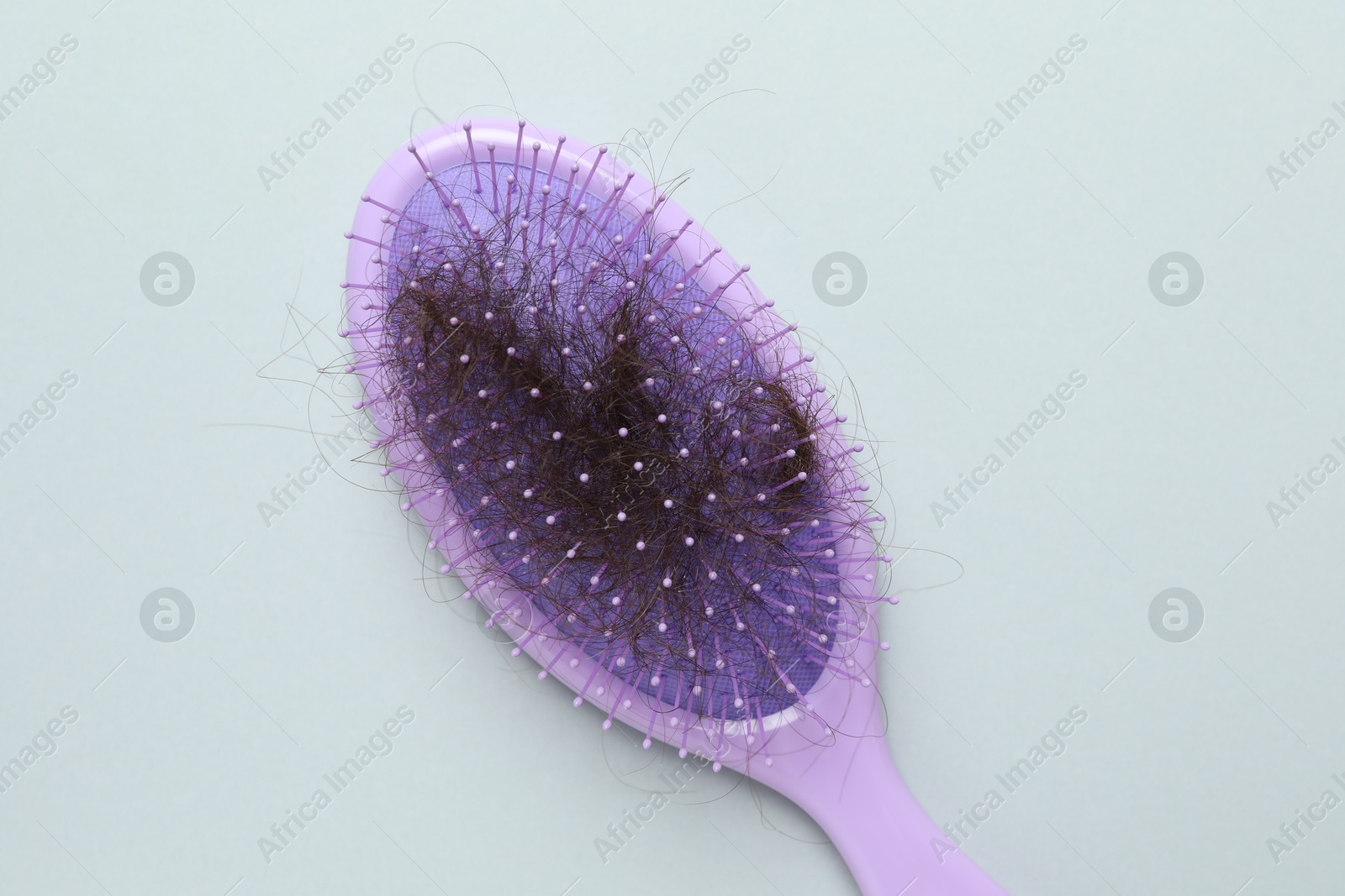 Photo of One brush with lost hair on grey background, top view. Alopecia problem