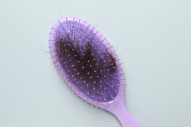 Photo of One brush with lost hair on grey background, top view. Alopecia problem