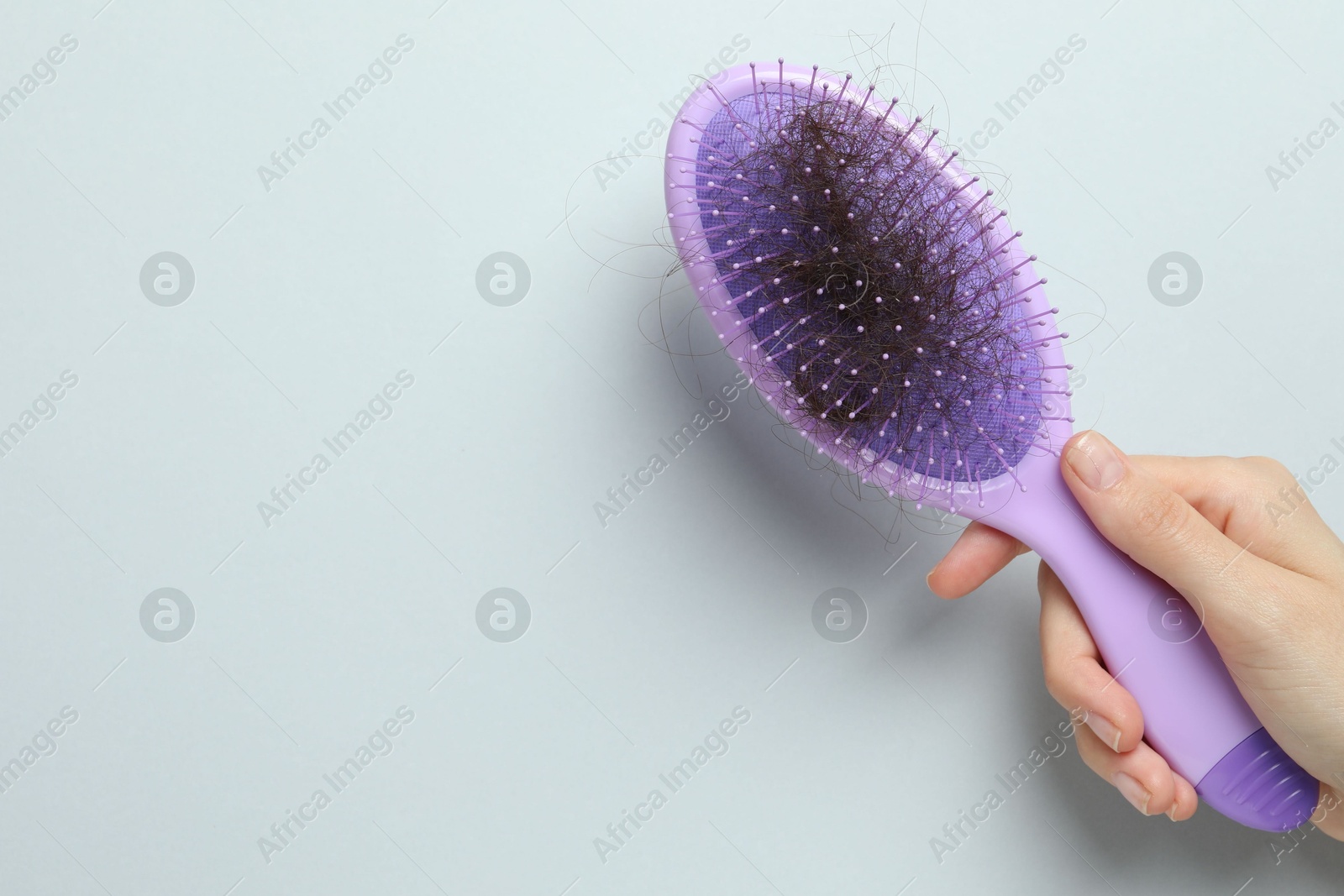 Photo of Woman with brush and lost hair on grey background, top view. Space for text