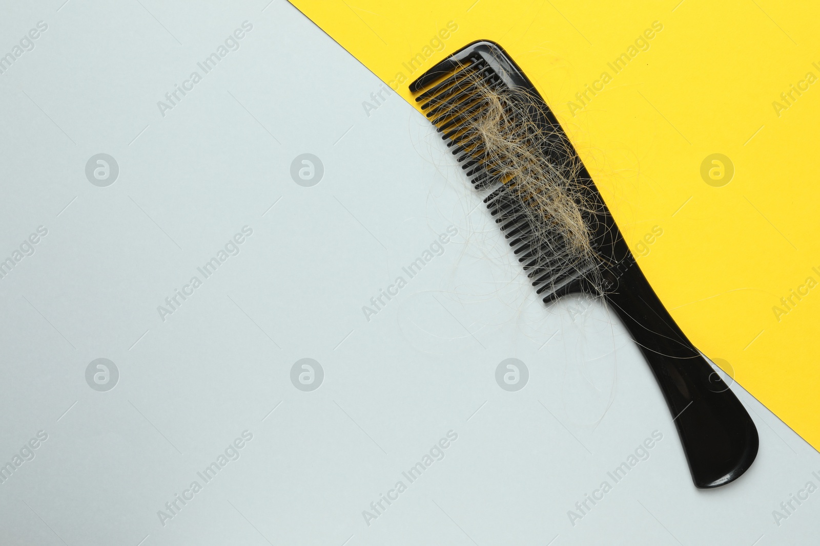 Photo of One comb with lost hair on color background, top view. Space for text