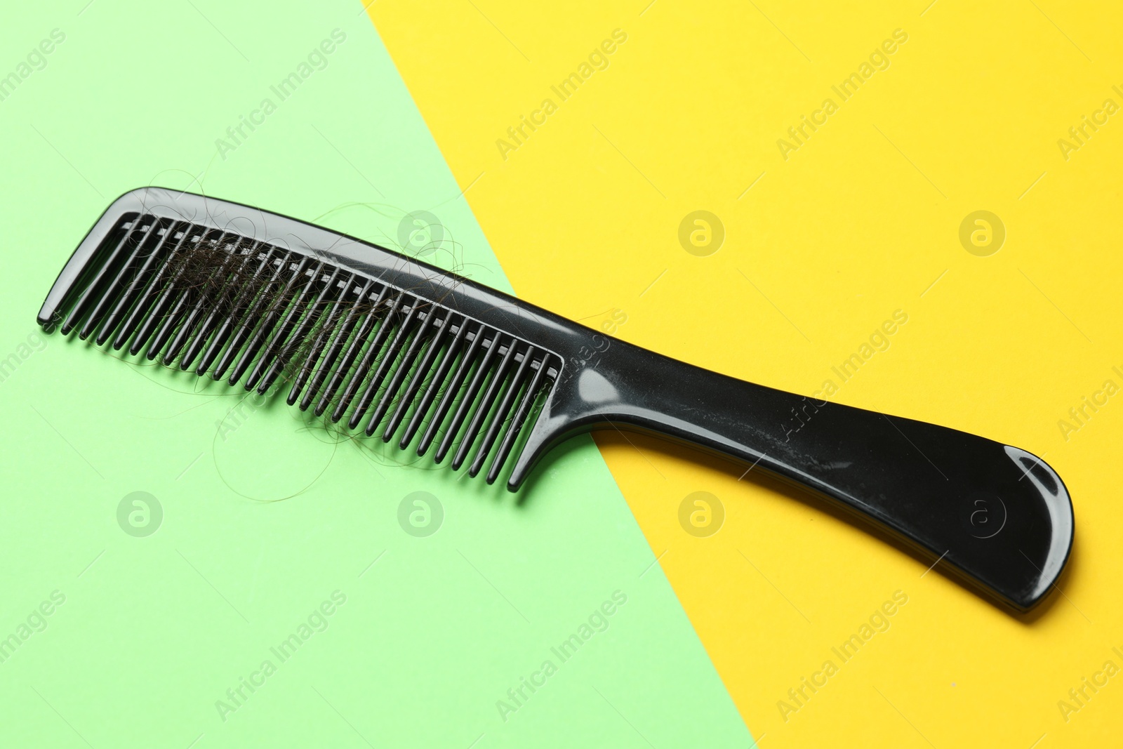 Photo of One comb with lost hair on color background. Alopecia problem