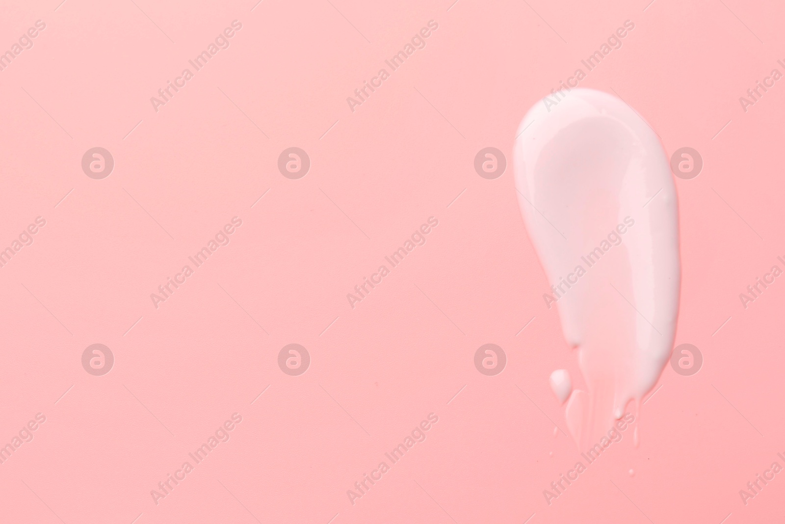 Photo of Sample of face cream on pink background, top view. Space for text