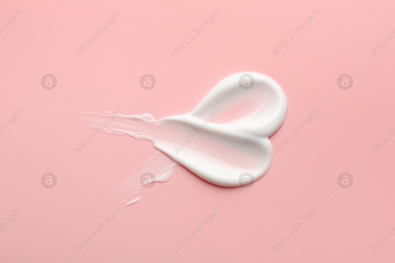 Photo of Sample of face cream on pink background, top view