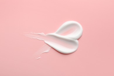 Photo of Sample of face cream on pink background, top view