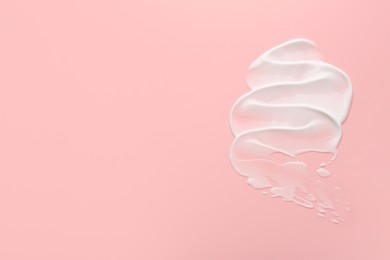 Photo of Sample of face cream on pink background, top view. Space for text