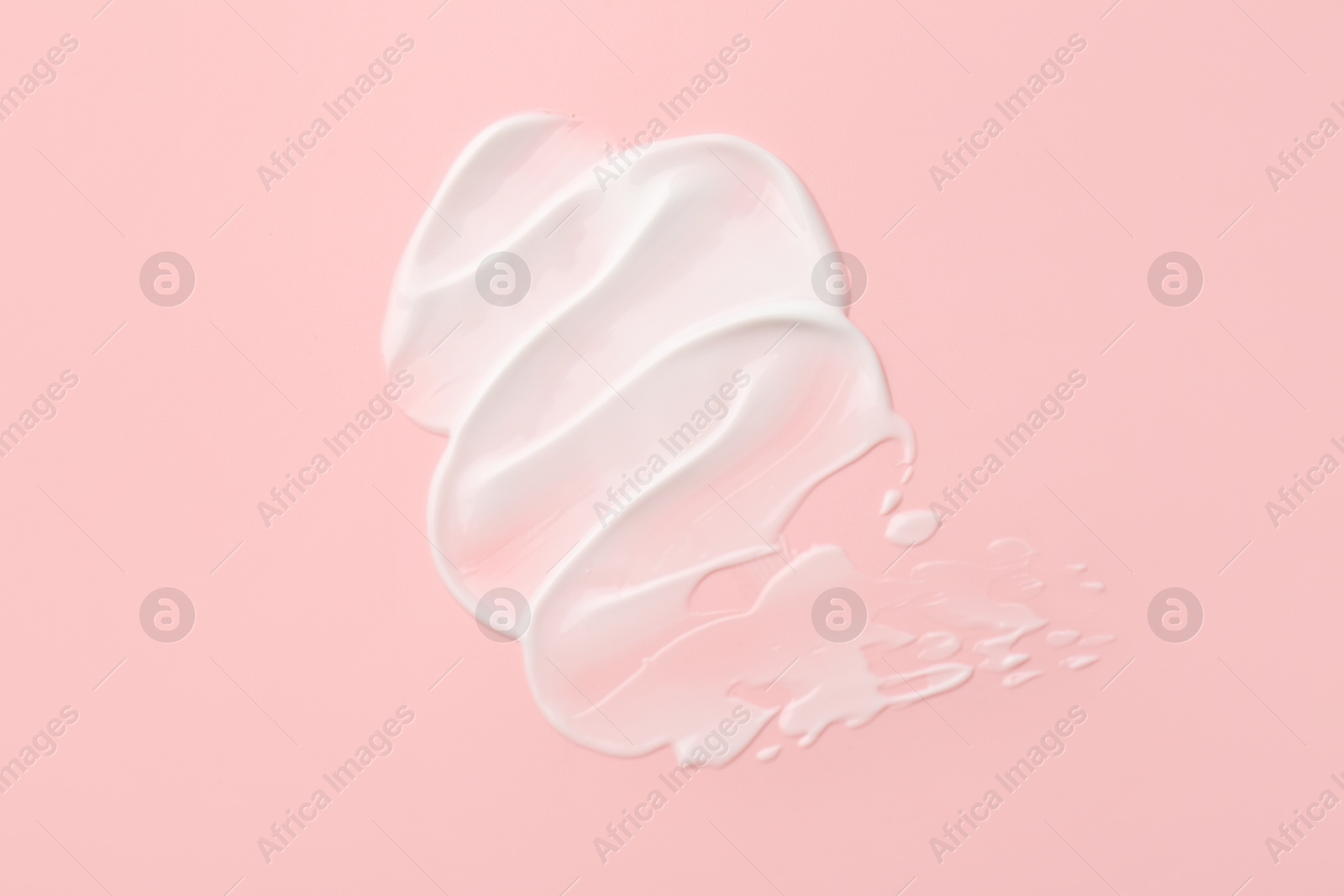 Photo of Sample of face cream on pink background, top view