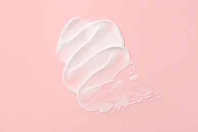 Photo of Sample of face cream on pink background, top view