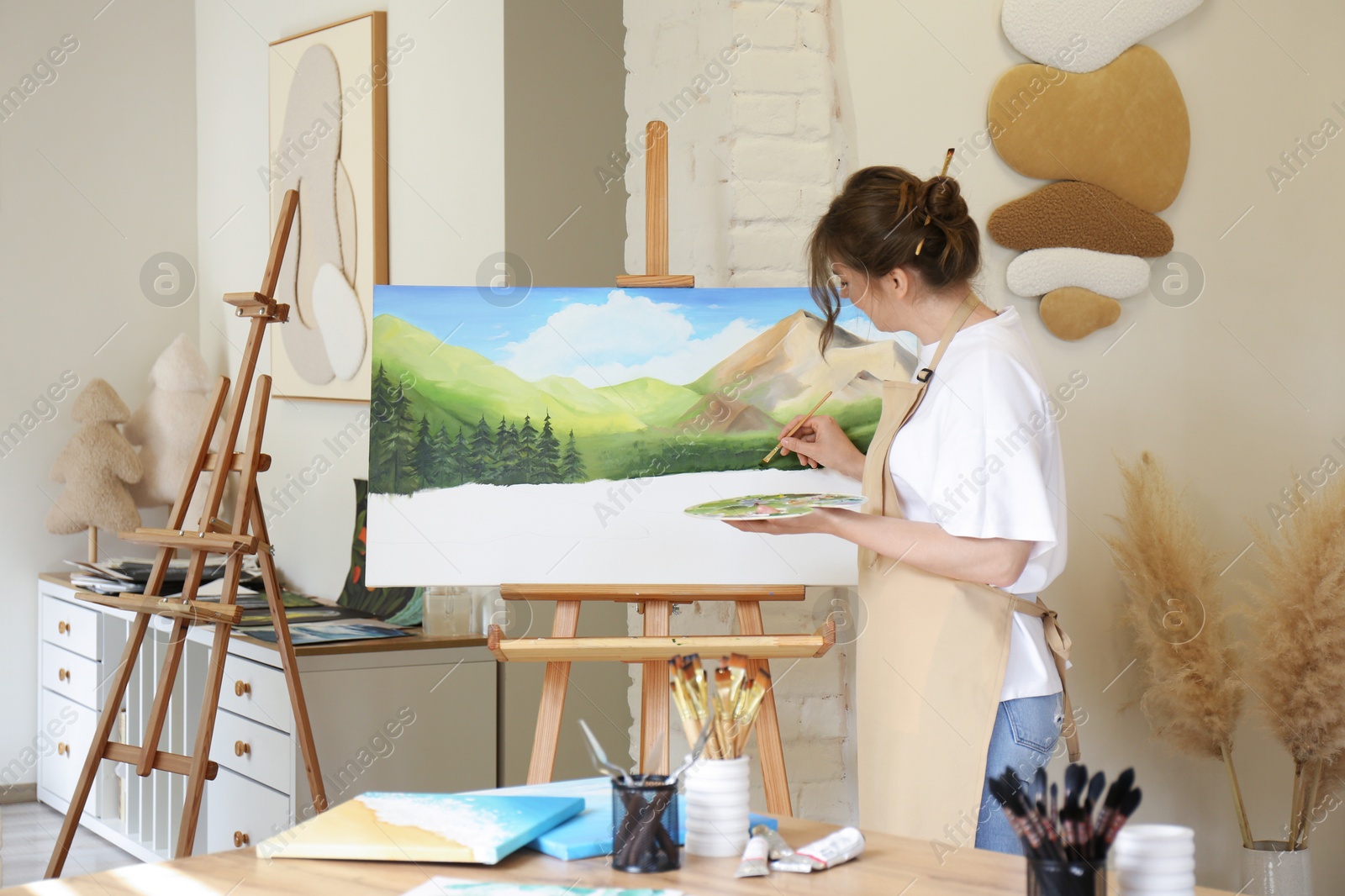 Photo of Woman drawing landscape with brush in studio