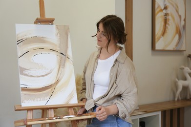 Photo of Portrait of woman with her artwork in drawing studio