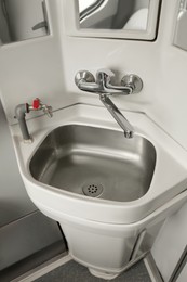 Photo of Stainless steel washbasin in train car restroom