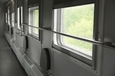 Photo of Windows and metal handrails in train car