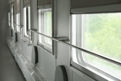 Photo of Windows and metal handrails in train car