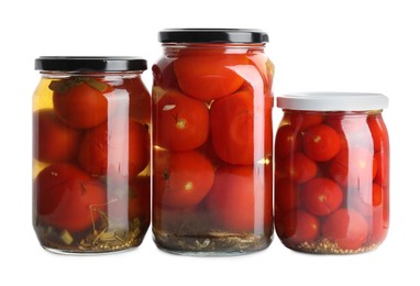Photo of Tasty pickled tomatoes in jars isolated on white