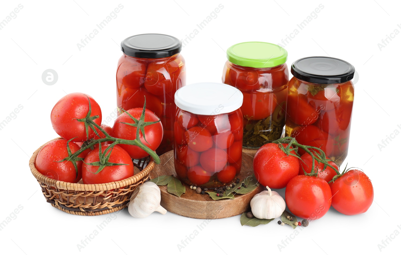 Photo of Tasty pickled tomatoes in jars, spices and vegetables isolated on white