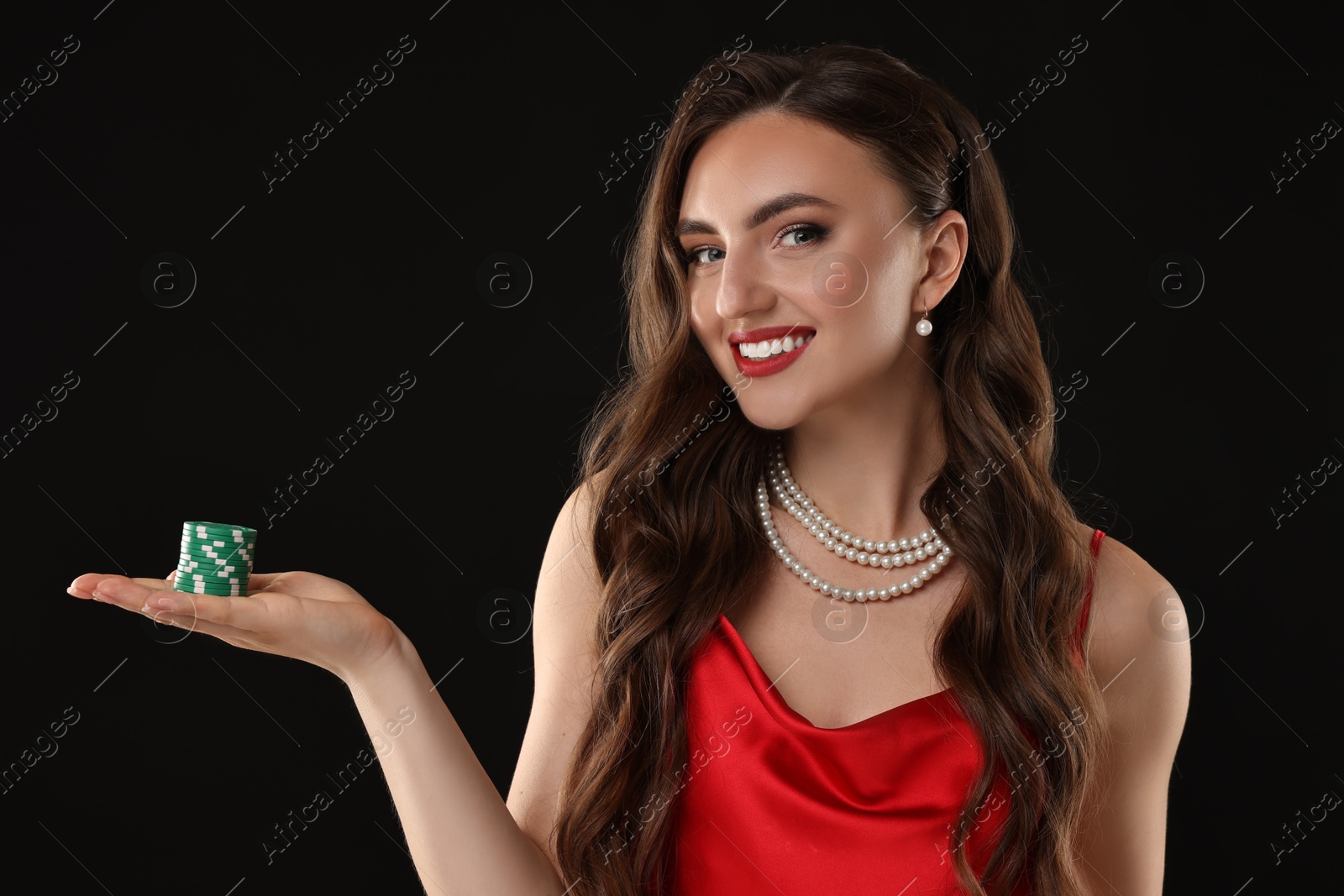 Photo of Smiling woman with poker chips on black background