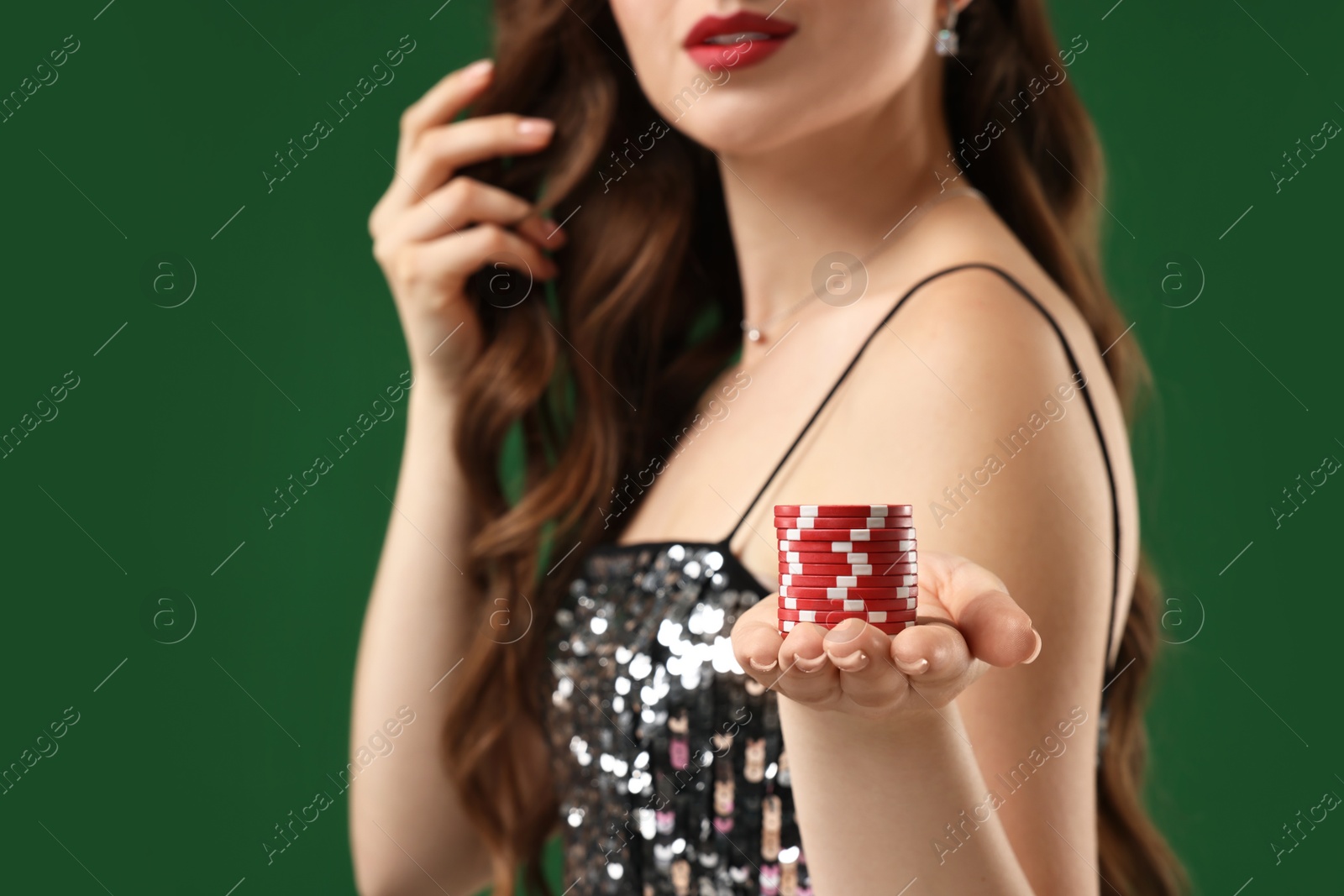 Photo of Woman with poker chips on green background, closeup